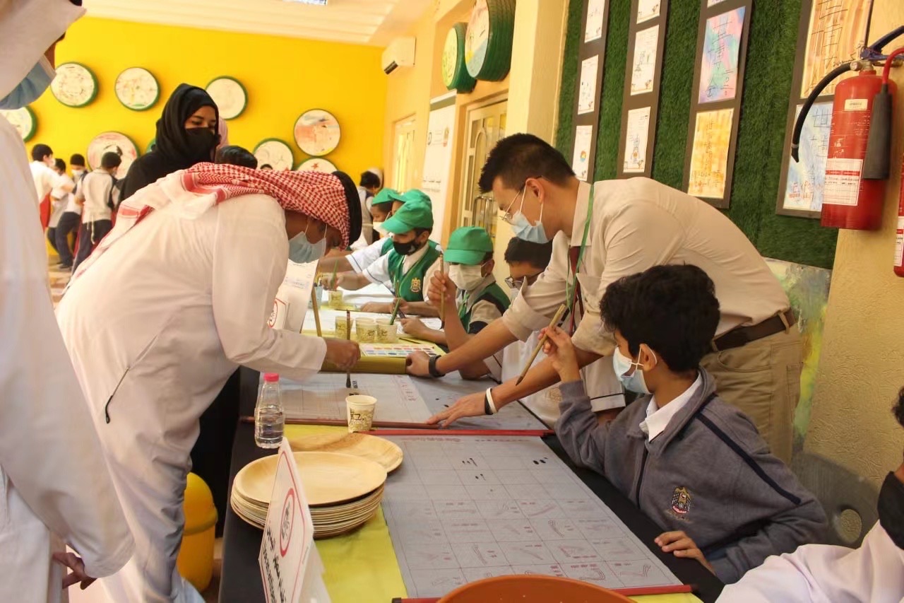 Shan Jin guiding students during an intercultural learning activity in a UAE school